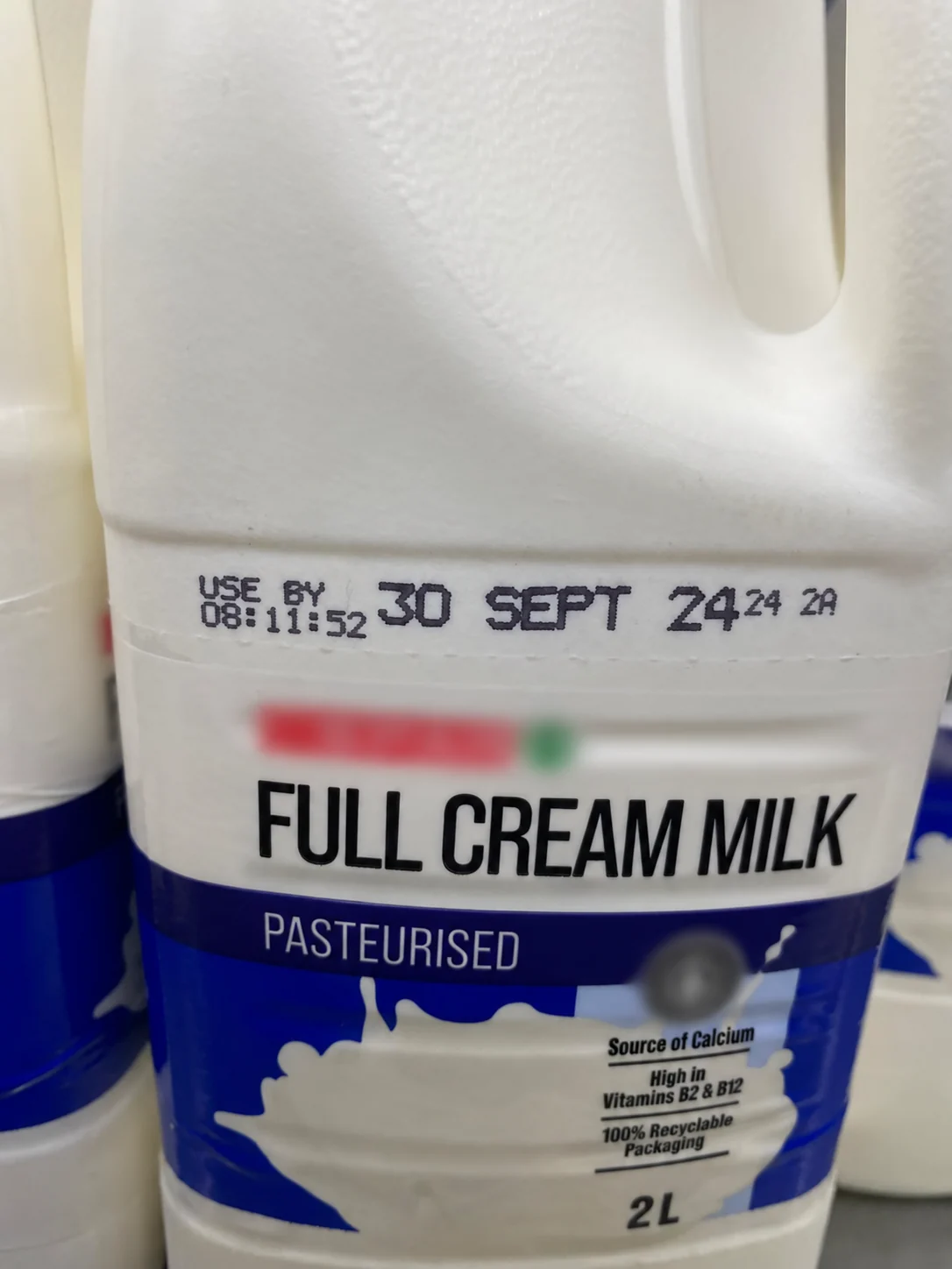 Large and small Hitachi UX-B date-code characters printed on a 2 L HDPE milk bottle
