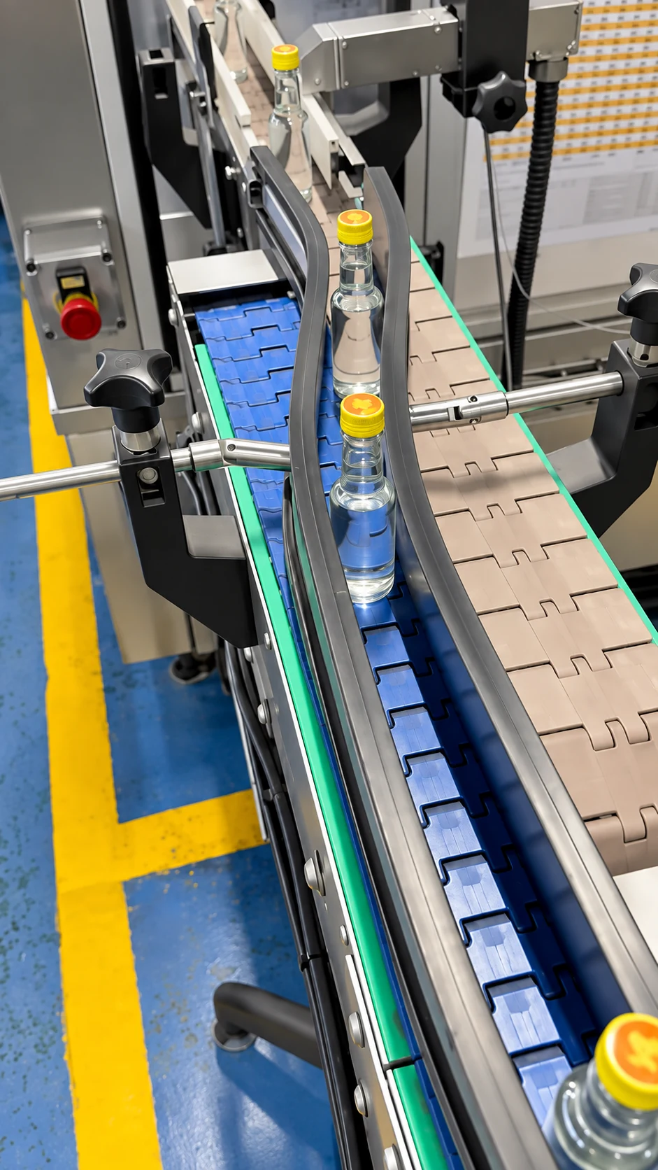 Small glass bottles entering a standalone label applicator on a beverage production line